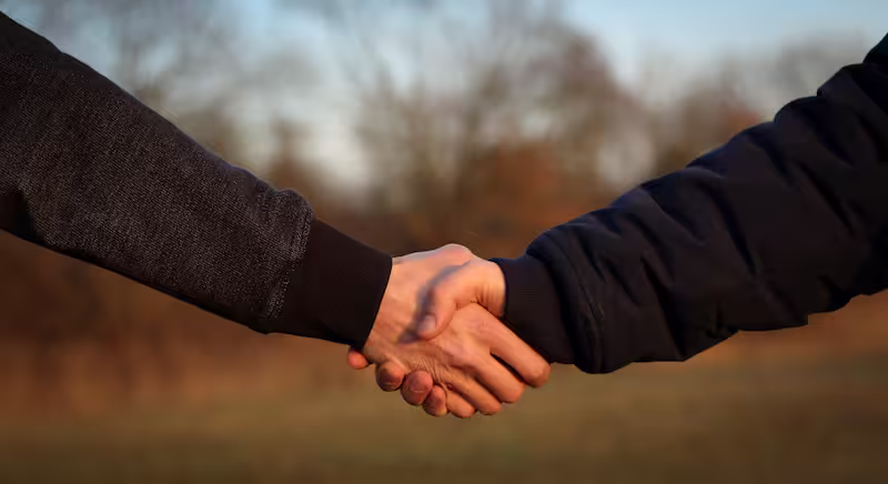 image de fond avec deux mains qui se serrent